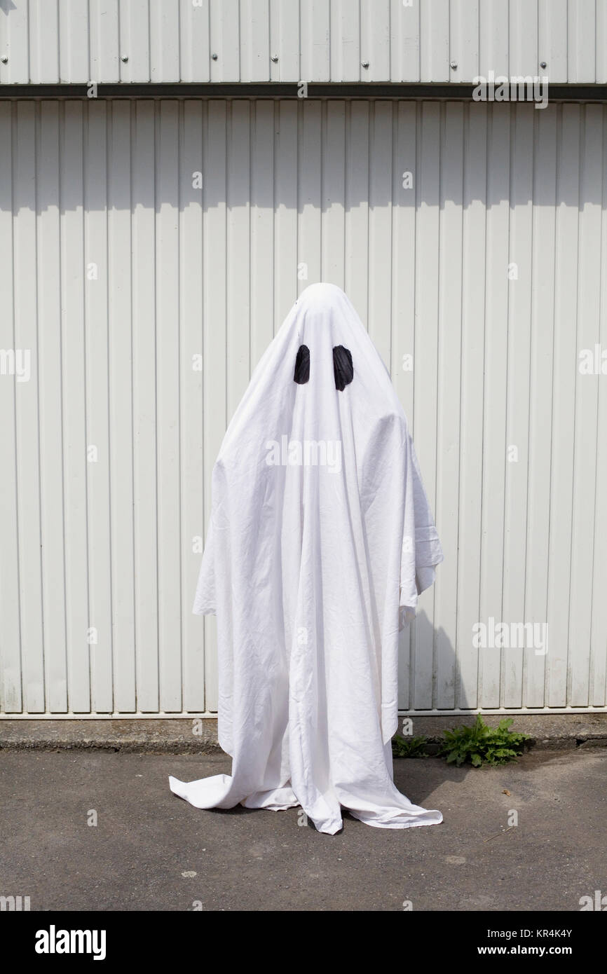 Un fantasma bianco di fronte a una porta di garage Foto Stock