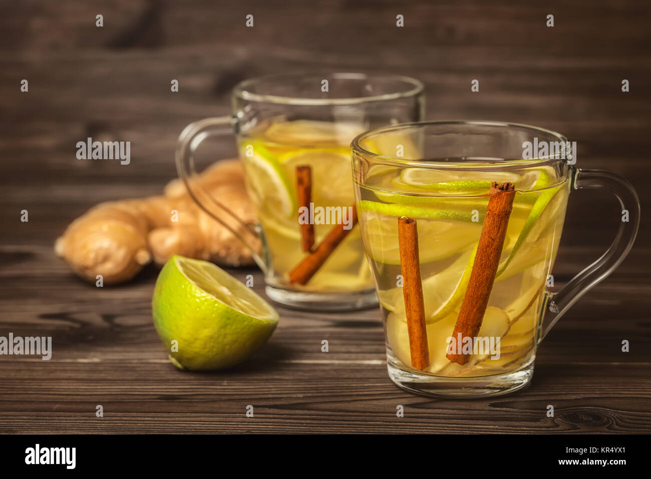 2 tazza di tè rilassanti con zenzero e lime e cannella su sfondo di legno, close up Foto Stock