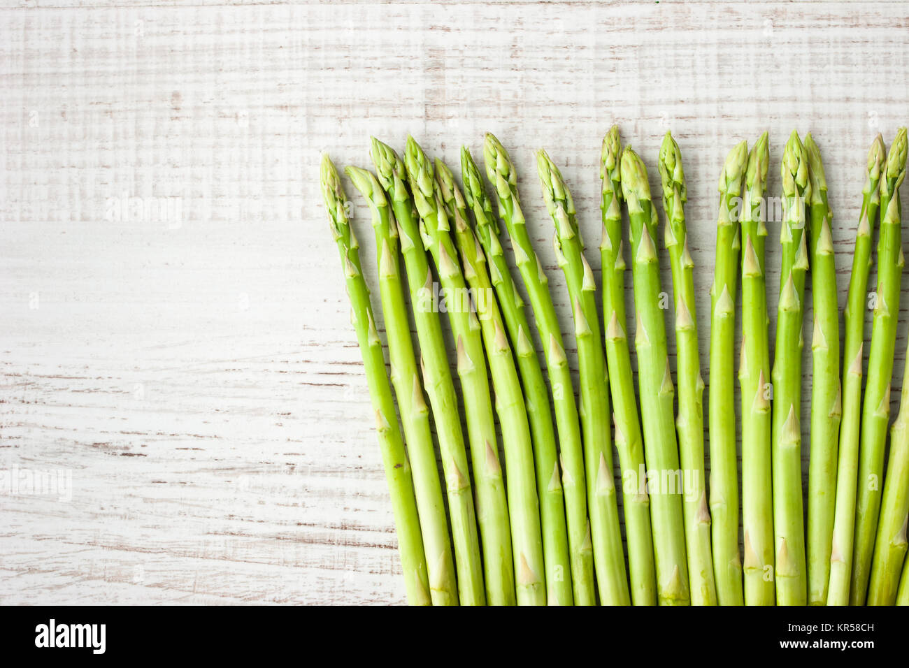 Rametti di asparagi sul tavolo bianco Foto Stock