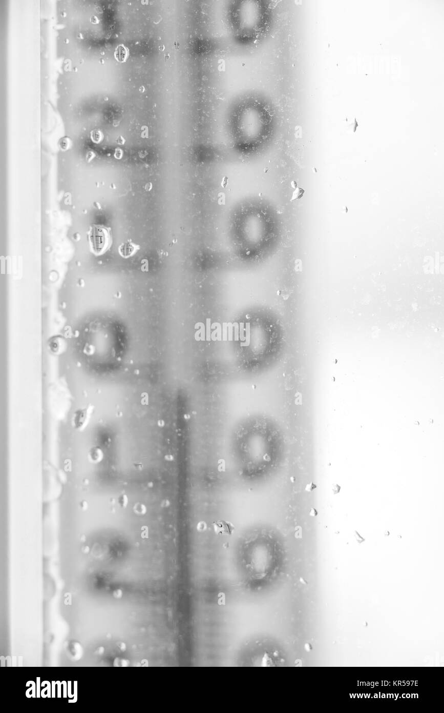 Termometro per finestra con vetro gocce di pioggia Foto Stock