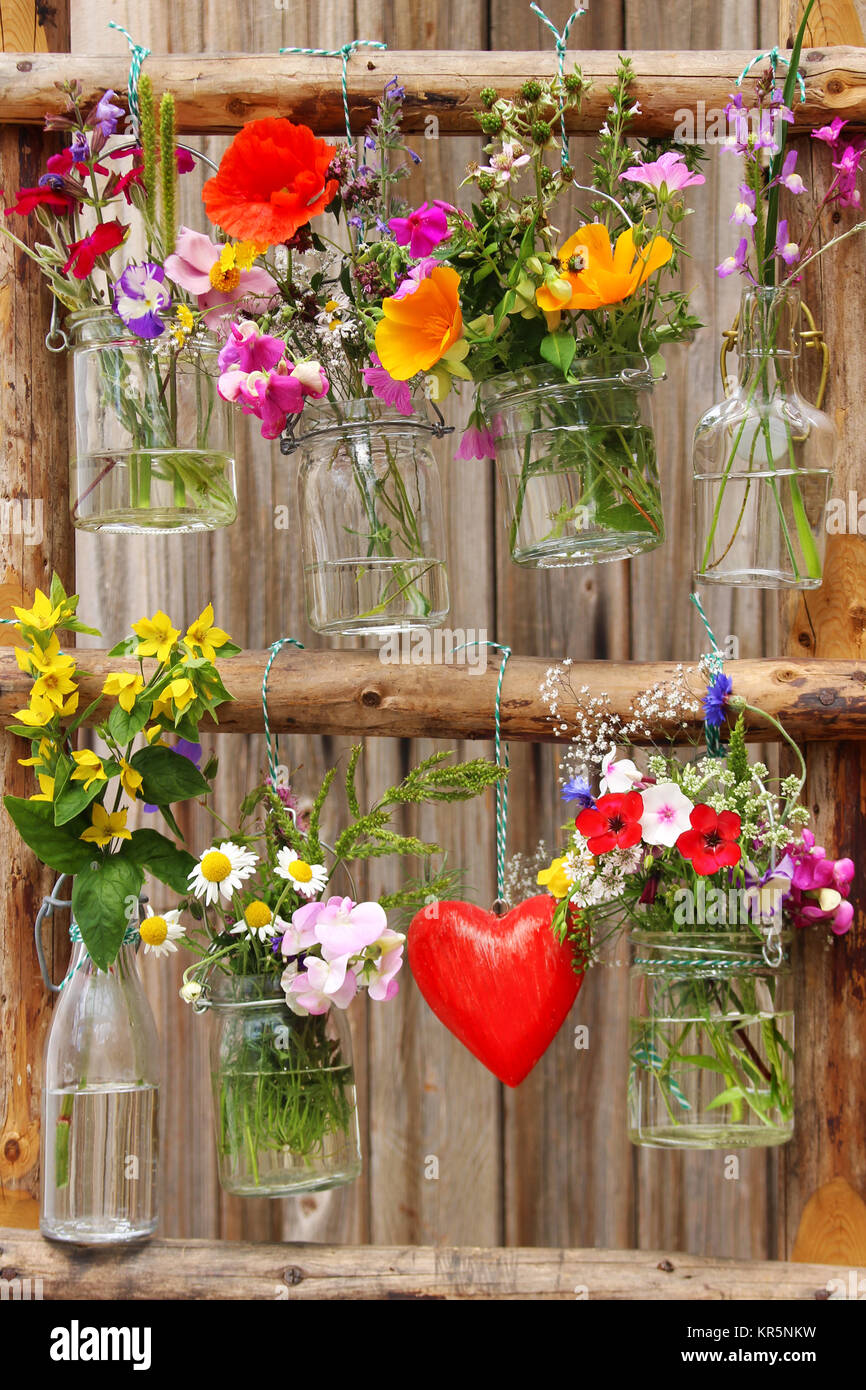 Fiori freschi appendere in bicchieri su una scaletta di legno Foto stock -  Alamy