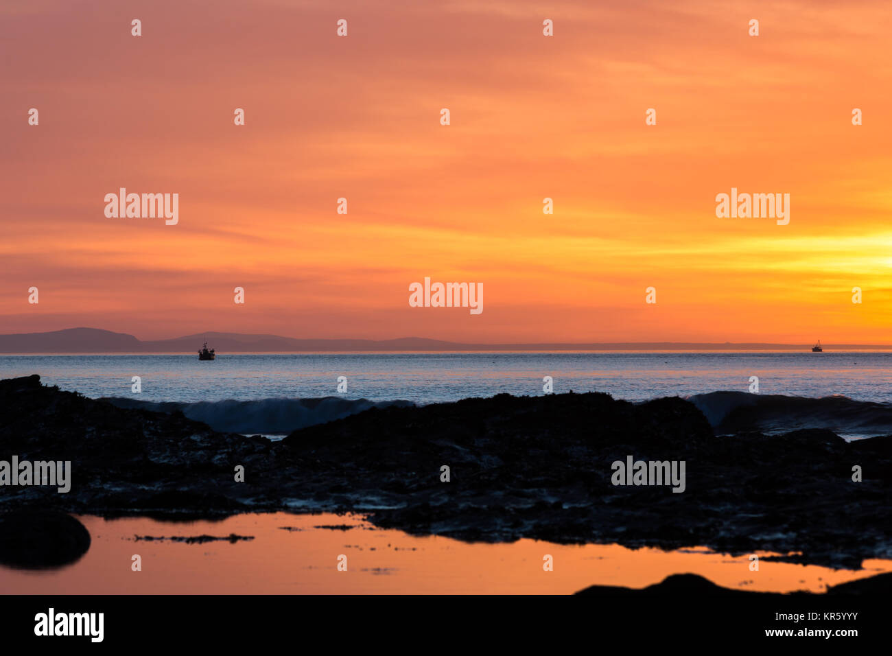 Una piccola barca da pesca su Cardigan Bay al tramonto Foto Stock