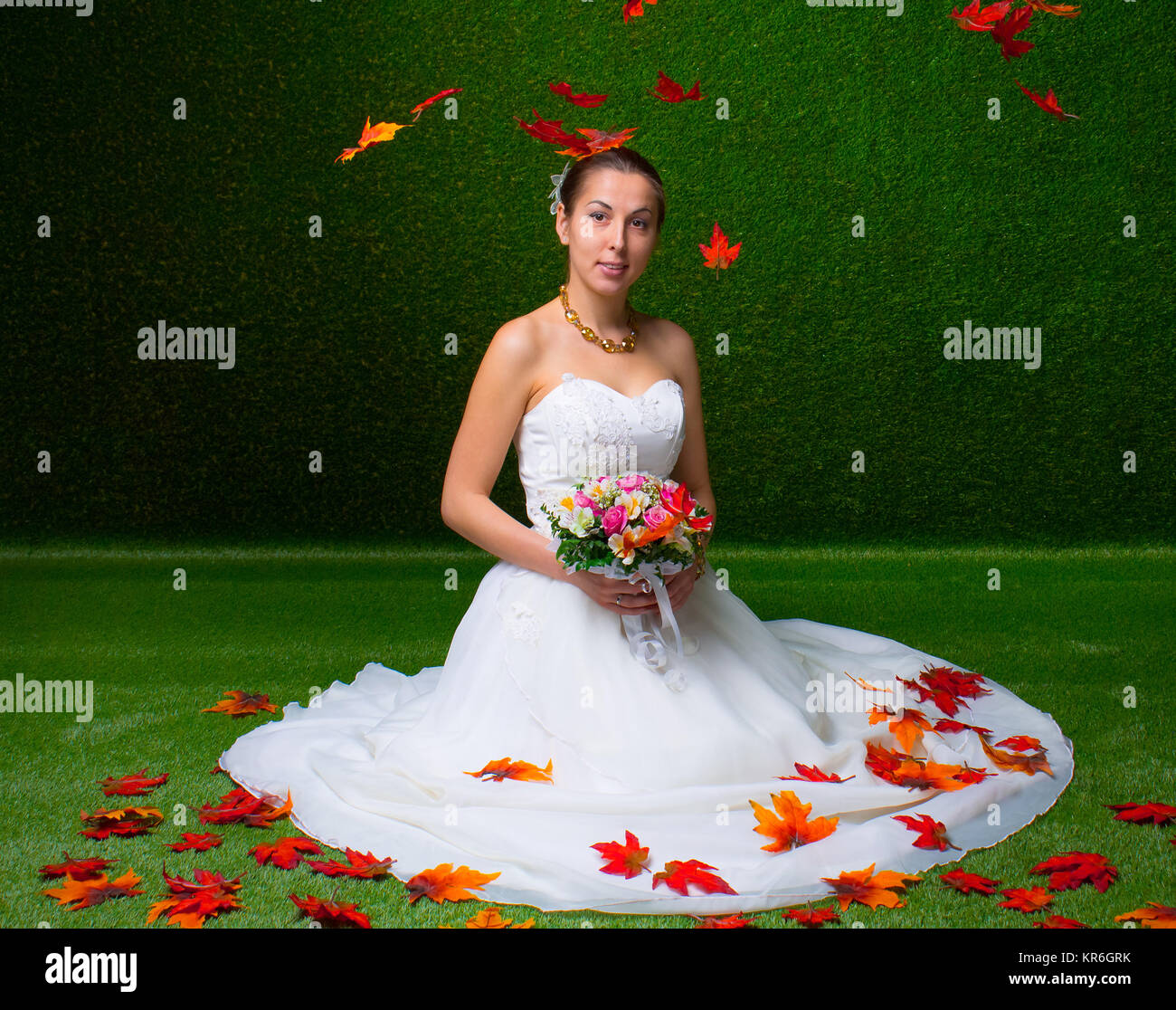 Giovane bella sposa con il mazzo di fiori e red maple leaf Foto Stock