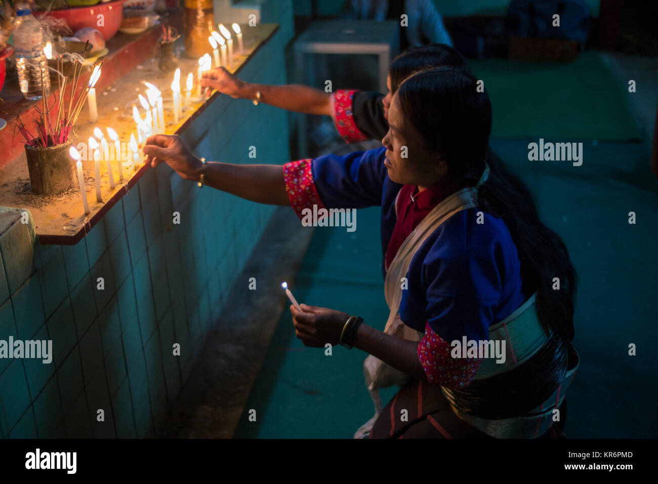 Donne birmane accendendo candele, Hsipaw Luna Piena festival, Birmania, Marzo 2012: due donne birmane sui costumi etnici accendono le candele a un altare buddista Foto Stock