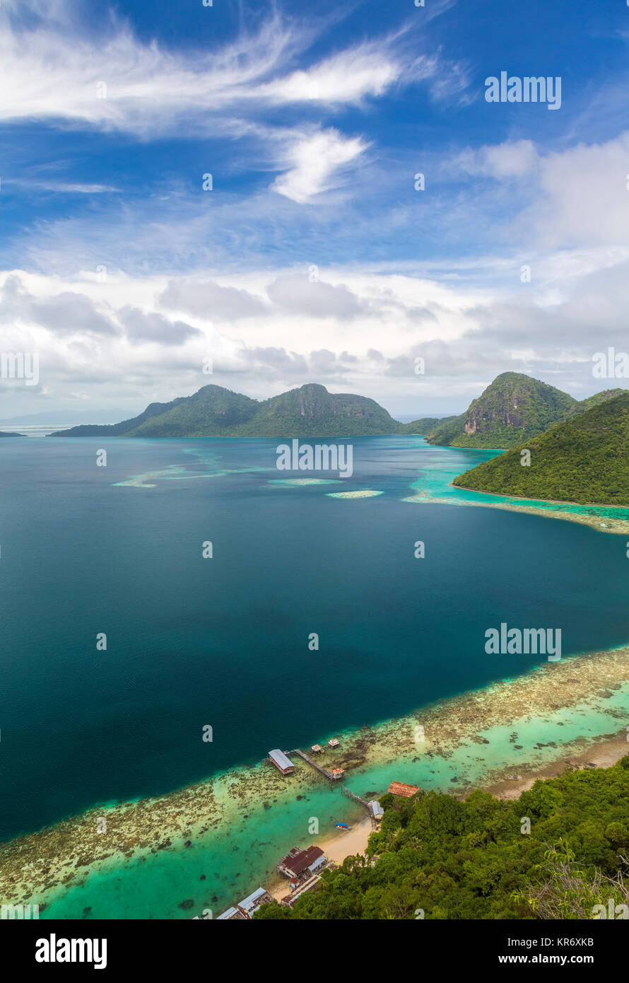 Angolo di alta vista lungo la costa di isola tropicale, montagne in distanza. Foto Stock