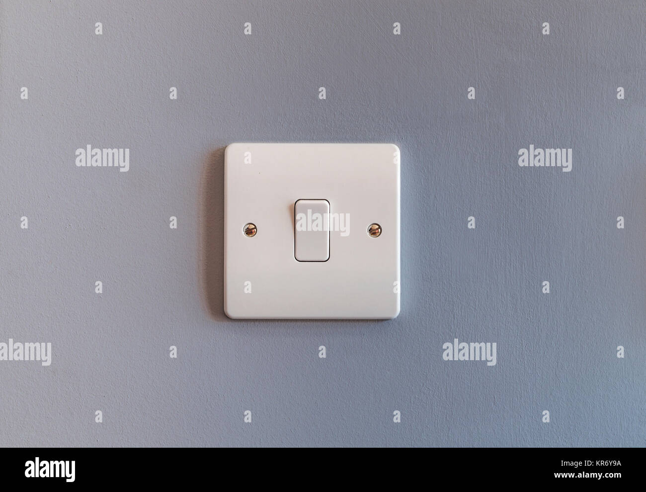 Voli domestici nel Regno Unito singolo interruttore luce in plastica bianca sul grigio di una parete colorata Foto Stock