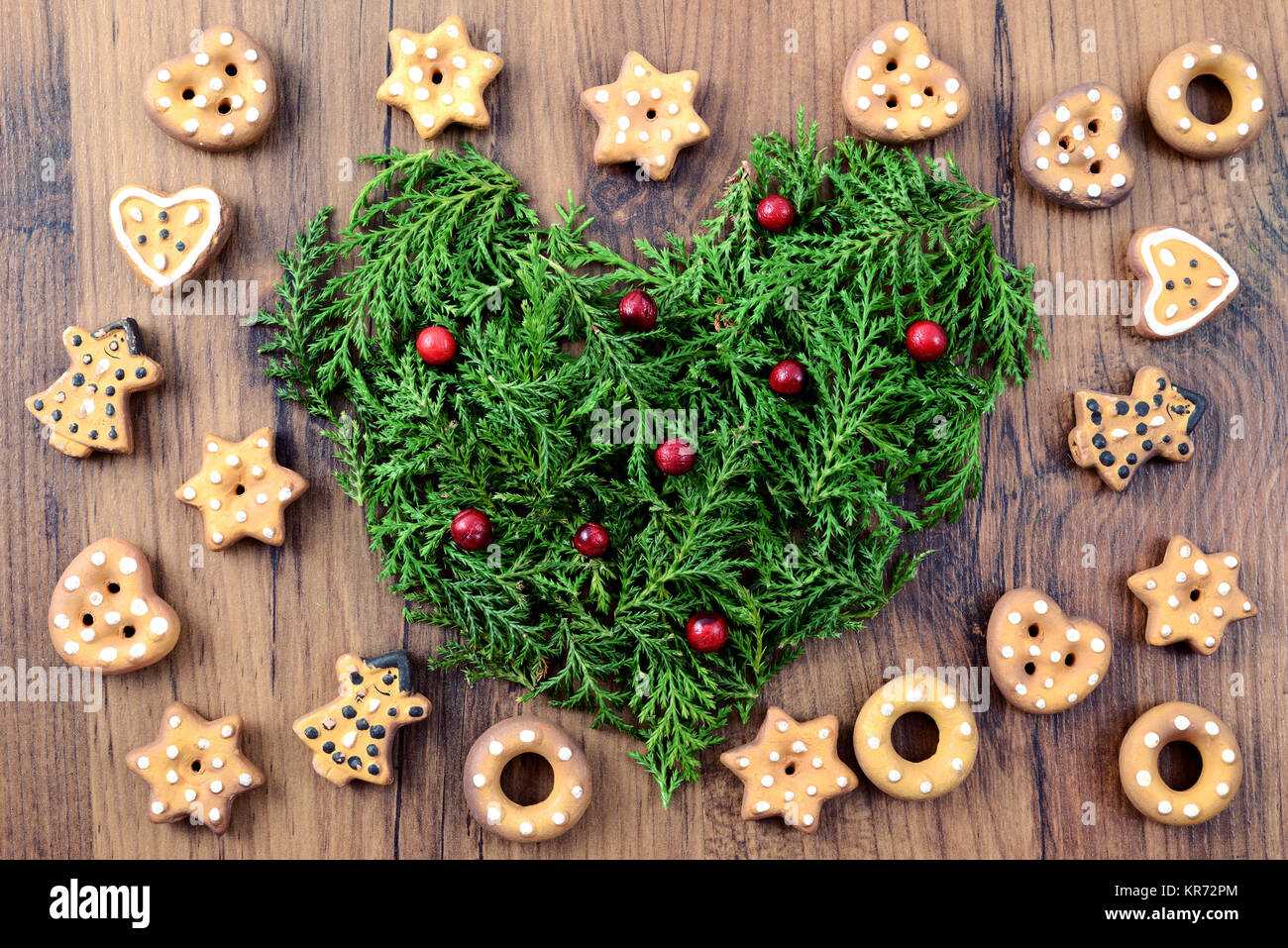 Natale sfondo da forno con i cookie e cuore di ramoscelli di pino con frutti rossi. Foto Stock