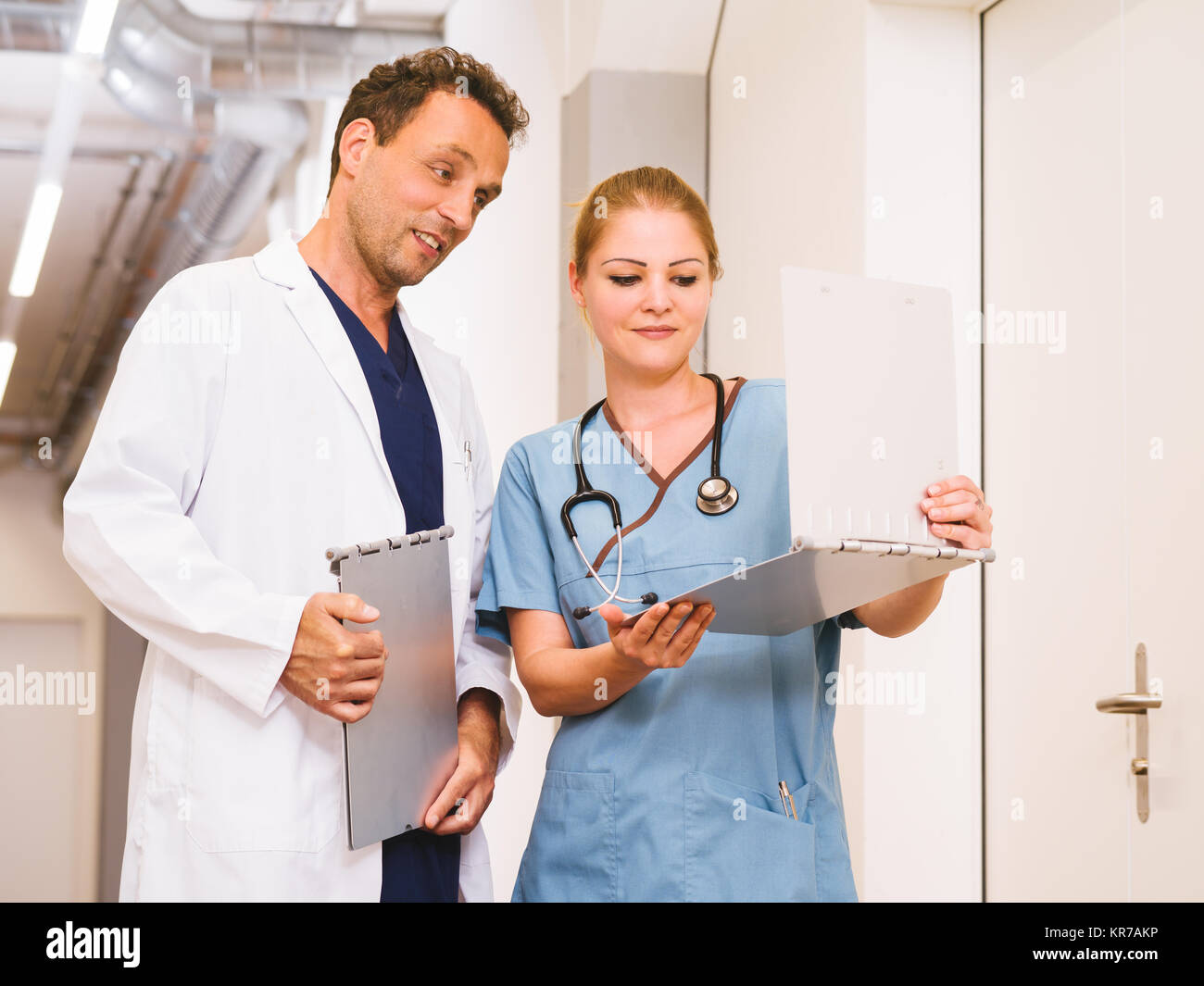 Medico e infermiere a discutere di grafici Foto Stock
