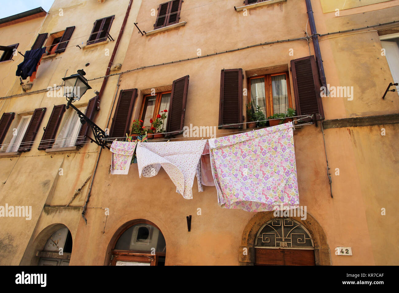 Uno stendibiancheria con lavanderia di una vecchia casa in Italia. appena lavato i vestiti di fronte a una casa Foto Stock