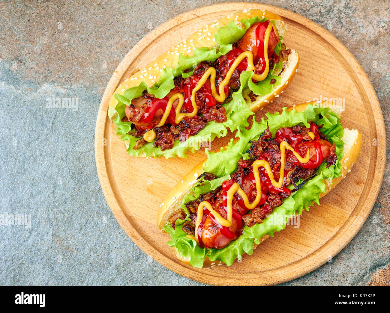 Due fatti in casa hot dogs con lattuga, la pancetta e la cipolla condimenti Foto Stock