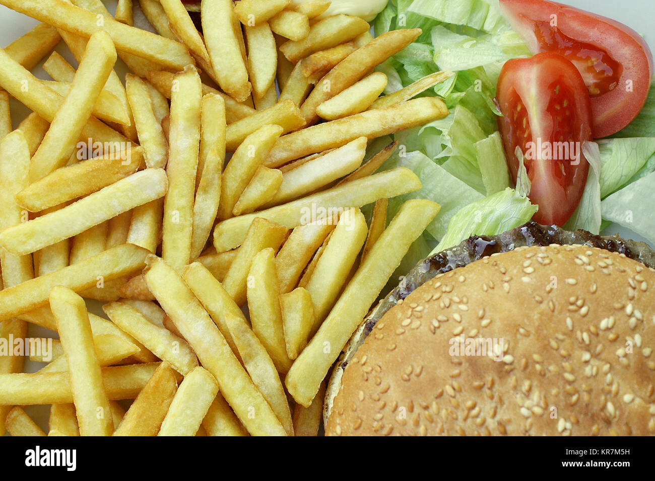 Una chiusura dalla parte superiore di patatine fritte Cheeseburger insalata e pomodori Foto Stock