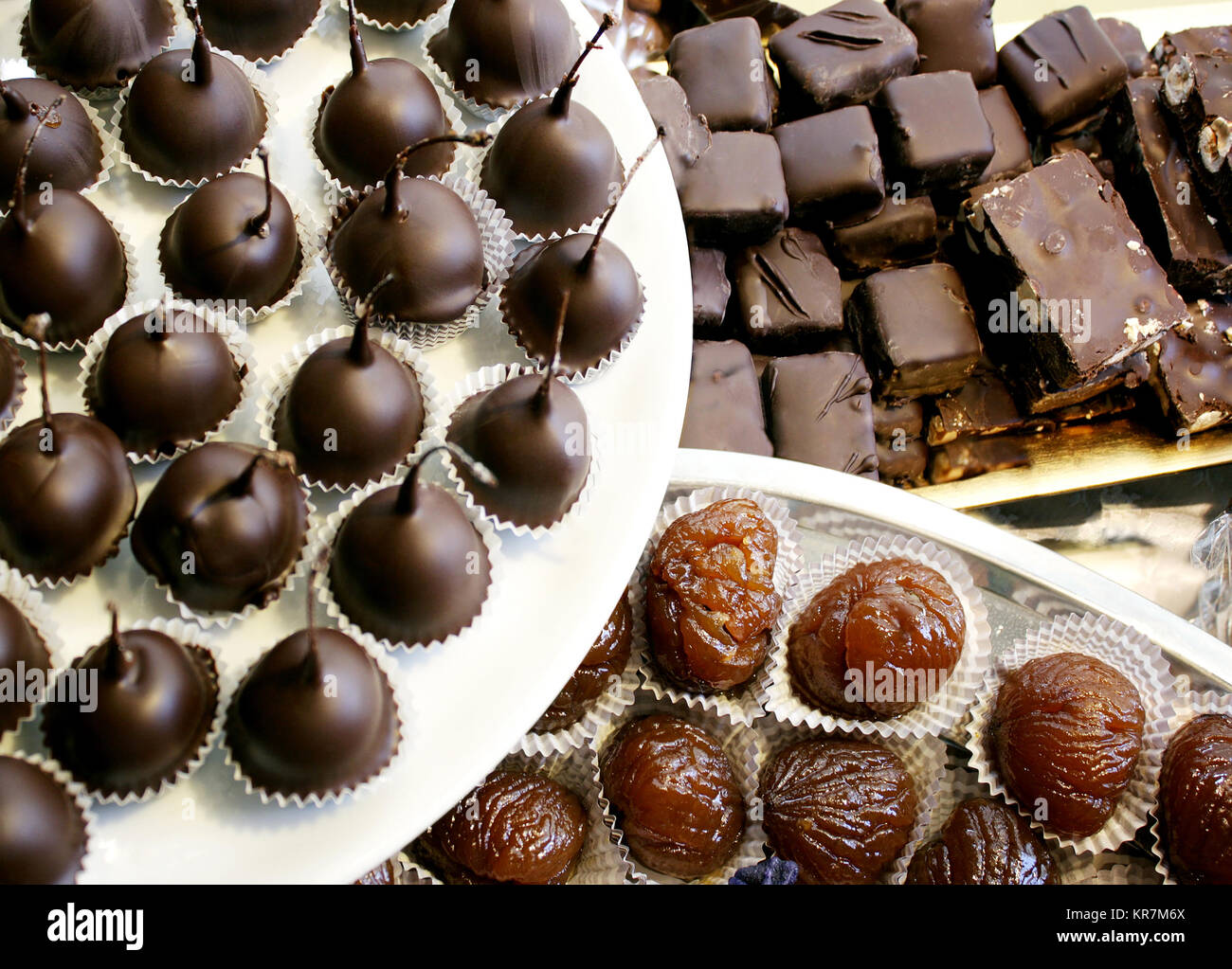 Dettaglio di molte ciliegie al maraschino ricoperto di cioccolato fondente, marron glace e scuro torrone al cioccolato Foto Stock