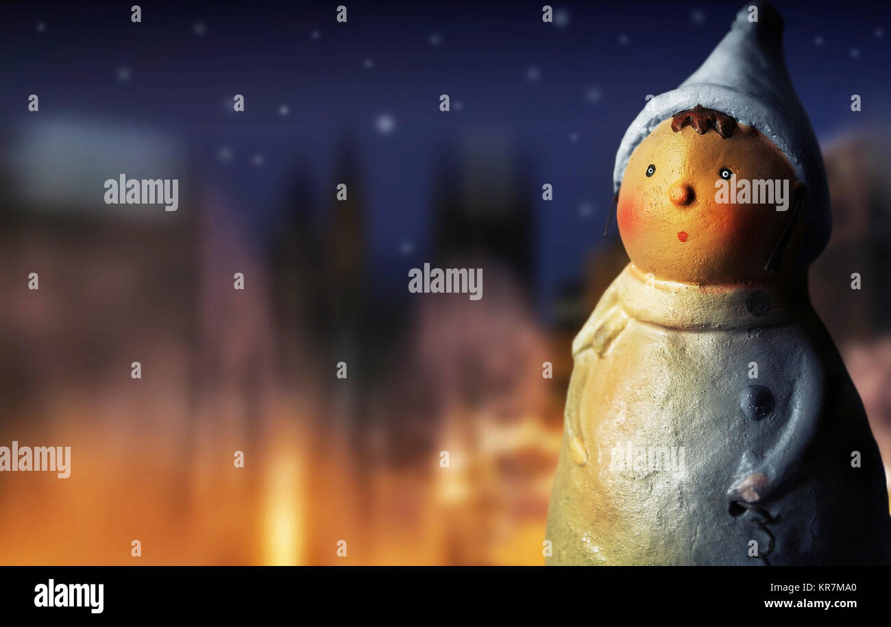 Fantastiche foto di un simpatico figurina fatti a mano nel fuoco dorato luce contro lo sfondo del cielo notturno e luci di inverno Foto Stock