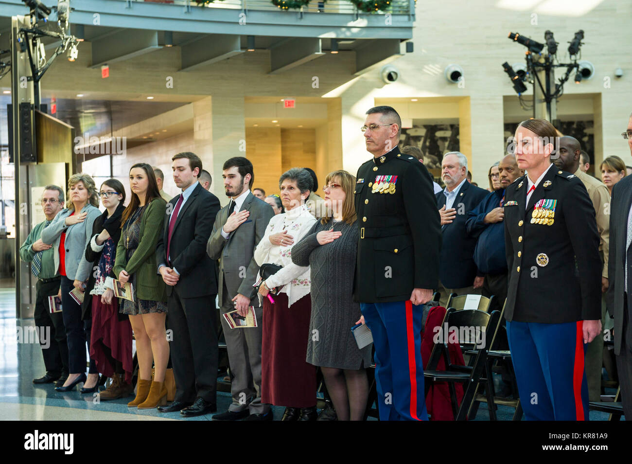 Stati Uniti Marines, la famiglia e gli amici di stand per la riproduzione dell'inno nazionale, durante una cerimonia di pensionamento per gli Stati Uniti Marine Corps Lt. Col. Giuseppe Uchytil, delegato, Marine Corps Cyberspace Operations Group, presso il Museo Nazionale del Marine Corps, Triangolo, Virginia, dal 1 dicembre 2017. Uchytil arruolato nel corpo della marina in 1992, ha ricevuto la sua ufficiale la messa in servizio nel 1997, e ha servito fedelmente per 26 anni. (U.S. Marine Corps Foto Stock