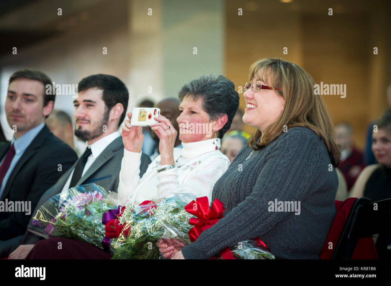 Katherine Uchytil, moglie di U.S. Marine Corps Lt. Col. Giuseppe Uchytil, delegato, Marine Corps Cyberspace Operations Group, sorride come suo marito parla durante la sua pensione cerimonia presso il Museo Nazionale del Marine Corps, Triangolo, Virginia, dal 1 dicembre 2017. Uchytil arruolato nel corpo della marina in 1992, ha ricevuto la sua ufficiale la messa in servizio nel 1997, e ha servito fedelmente per 26 anni. (U.S. Marine Corps Foto Stock