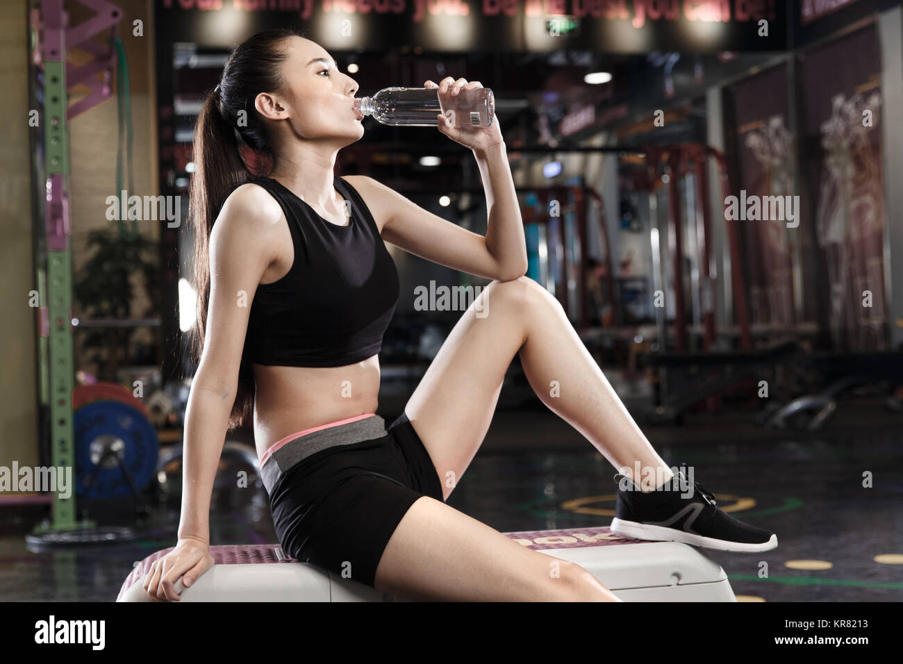 Giovani donne bere acqua in palestra Foto Stock