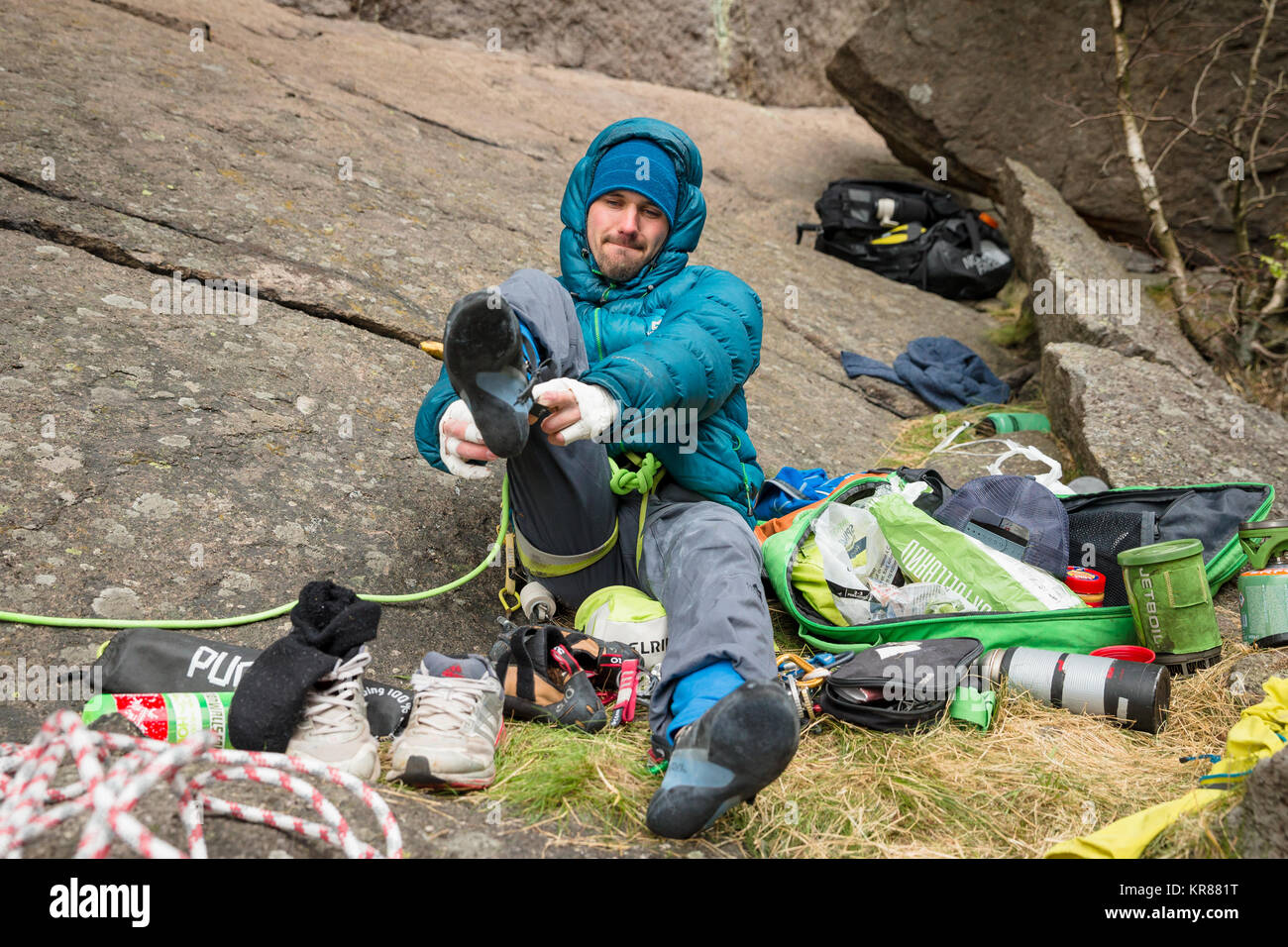Un uomo mette le sue scarpe da arrampicata su Foto Stock