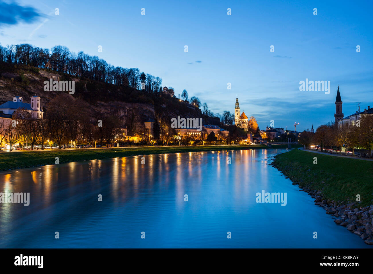 Austria, Salisburgo, Fiume e illuminato in riva al crepuscolo Foto Stock