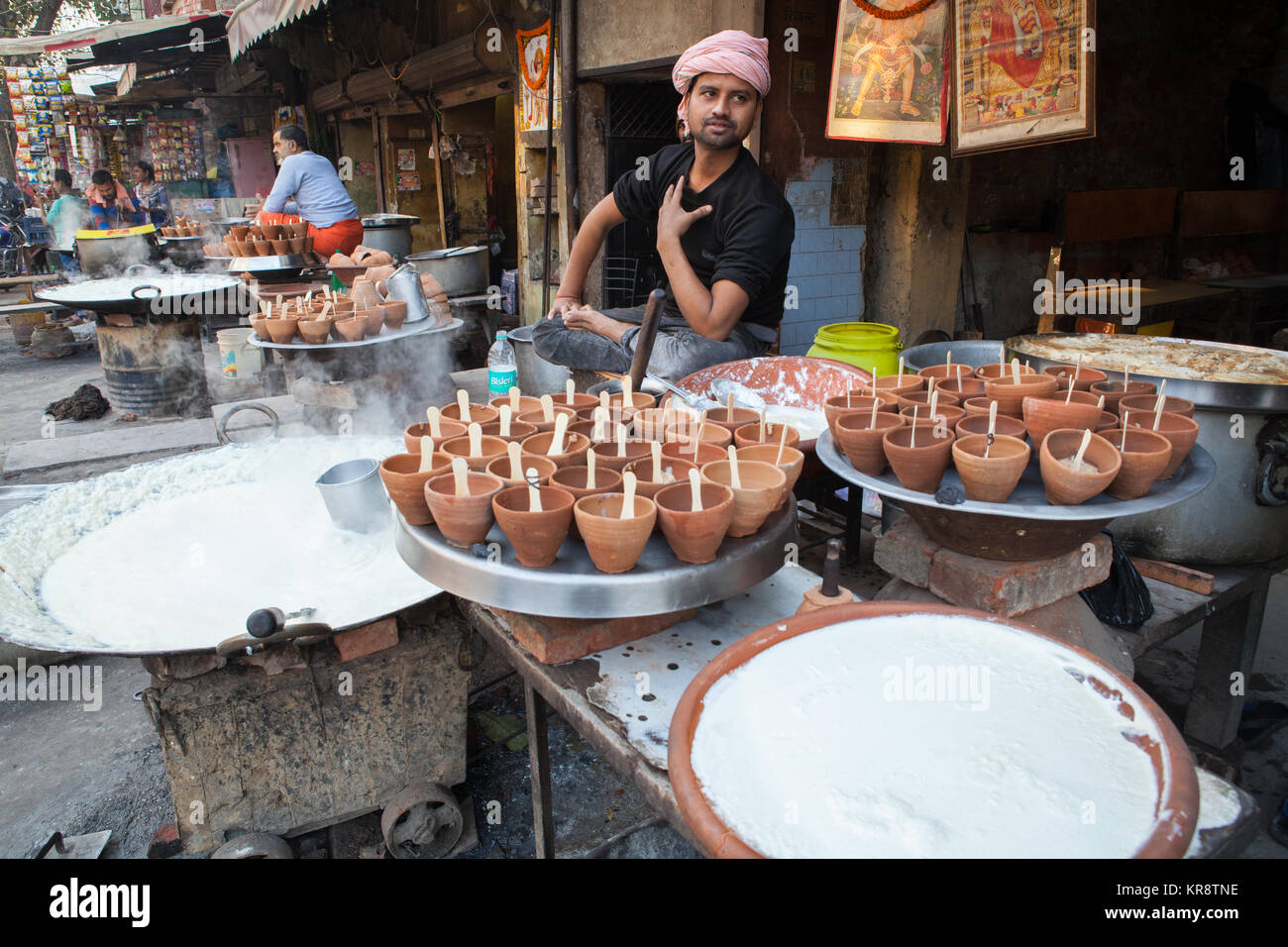 Un venditore a vendere pentole di mishti doi (dolce curd) presso un hotel di cibo in Allahabad, India Foto Stock