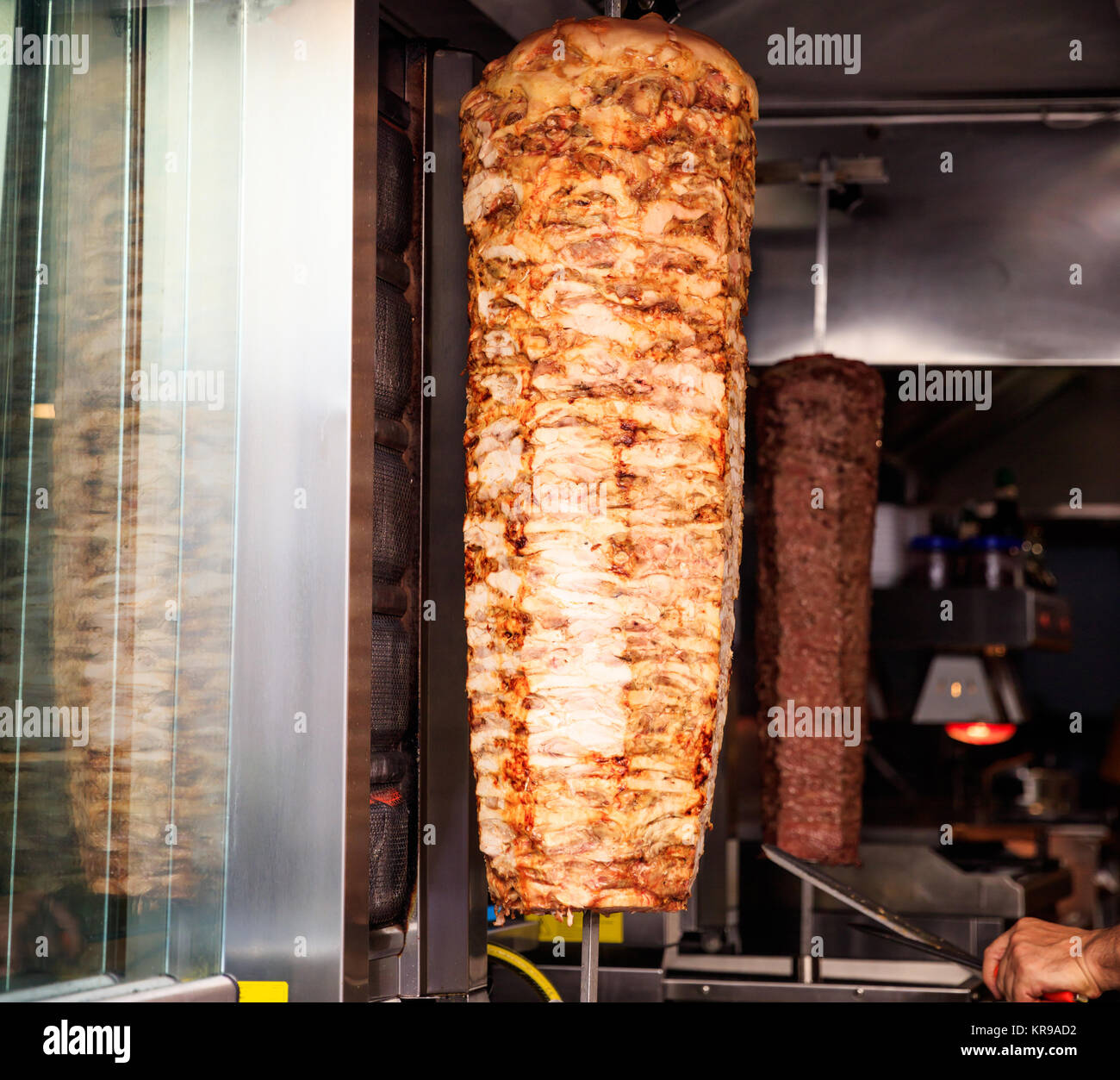 Gyros, döner lentamente alla griglia su spiedo rotante. Sfondo sfocato. Foto Stock