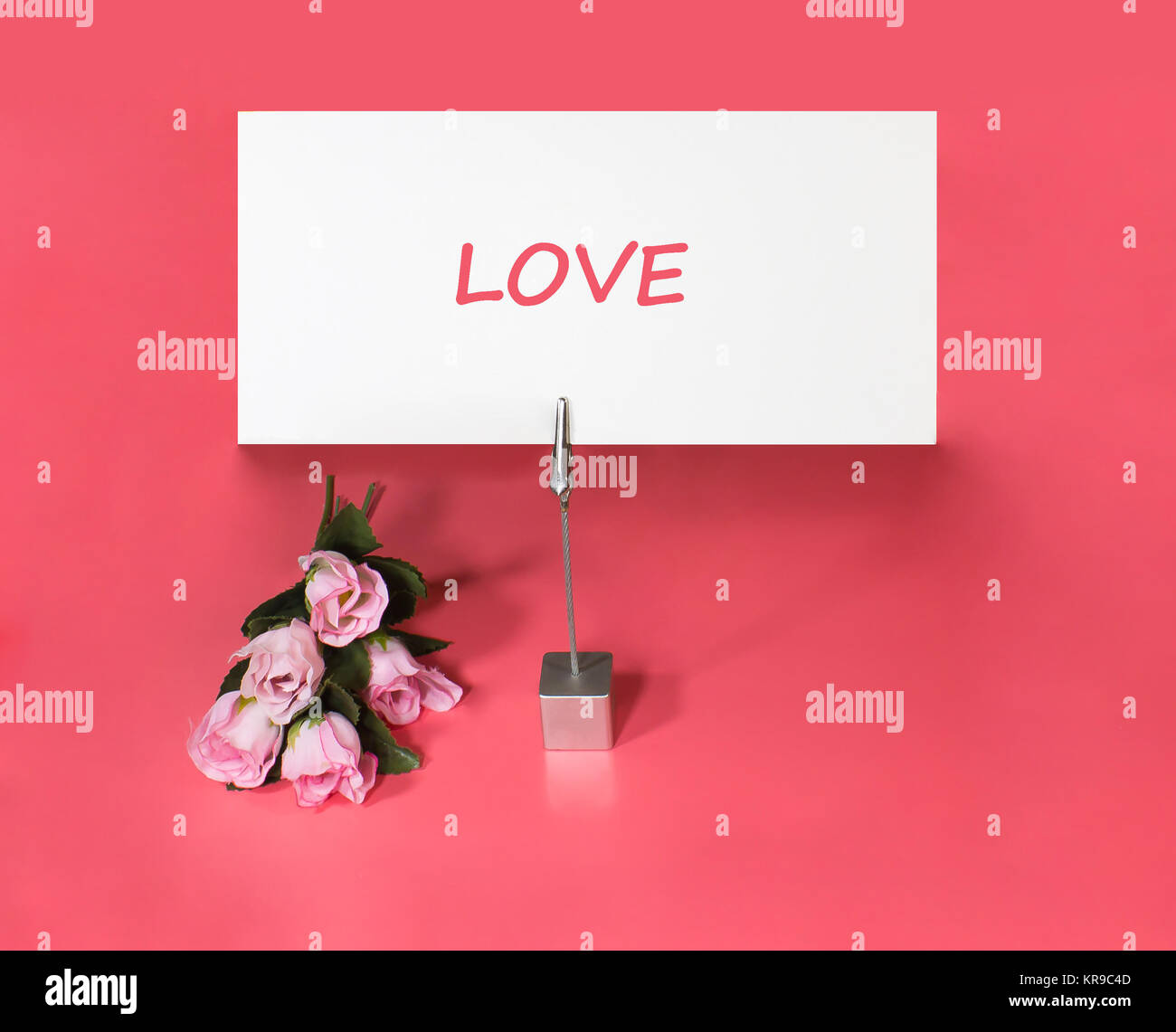 Nota titolare con rose e carta la parola amore Foto Stock