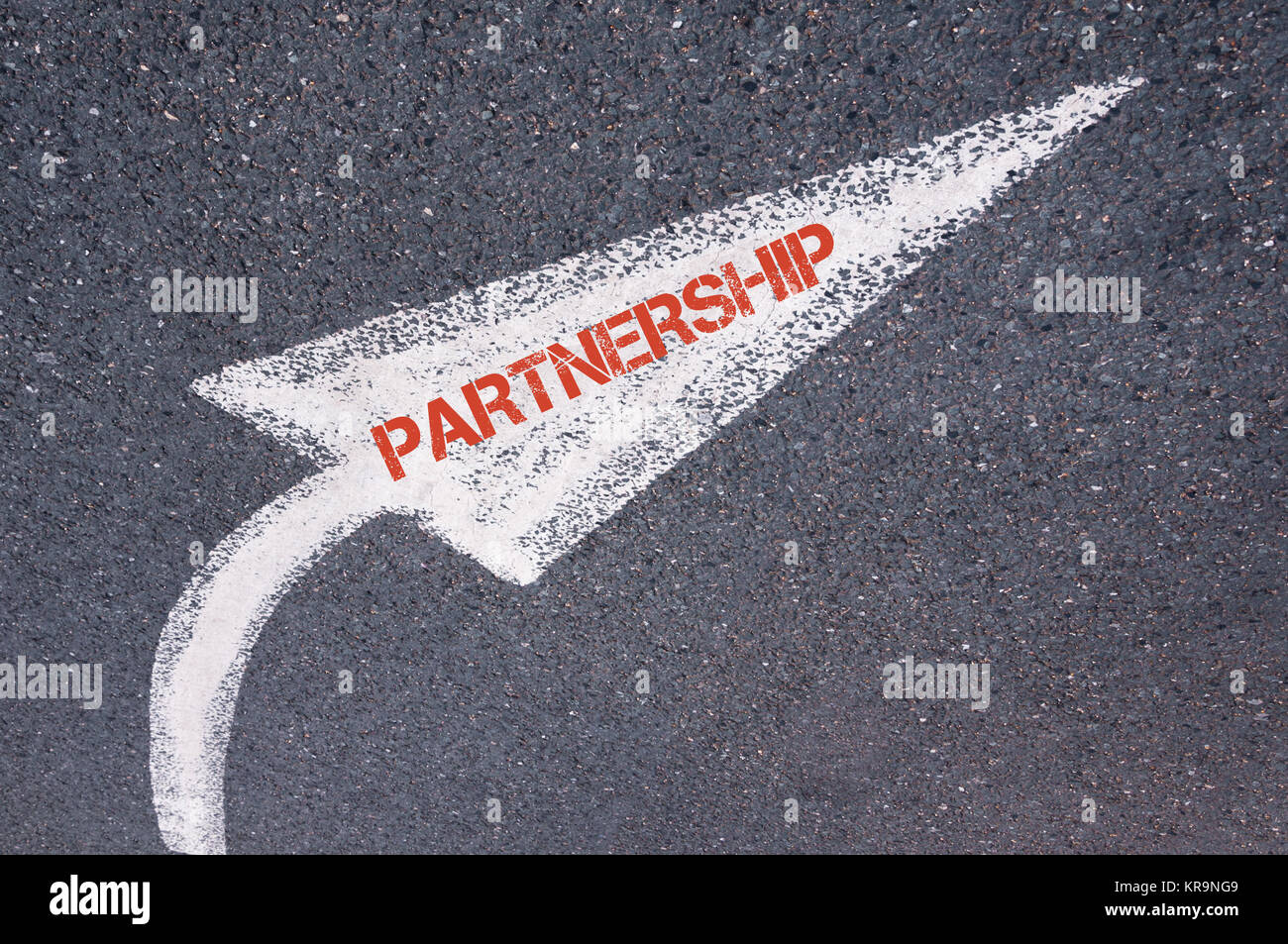 Direzionale dipinte di bianco freccia con parola partnership oltre la superficie stradale Foto Stock