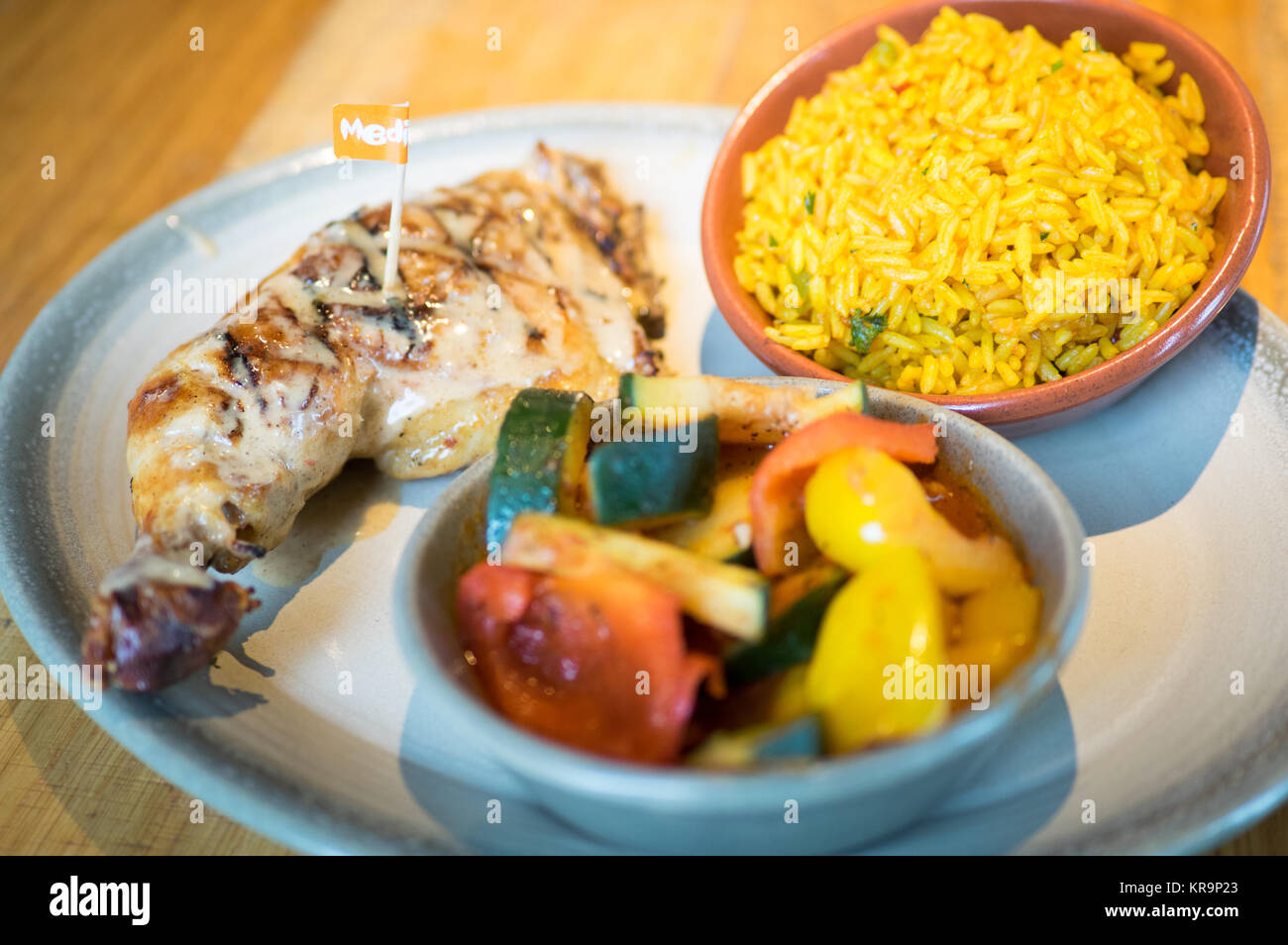 Peri-peri quarto di pollo con i lati di riso speziato e peri-peri verdura da Nando's, un casual dining catena che proviene dal Sud Africa. Foto Stock