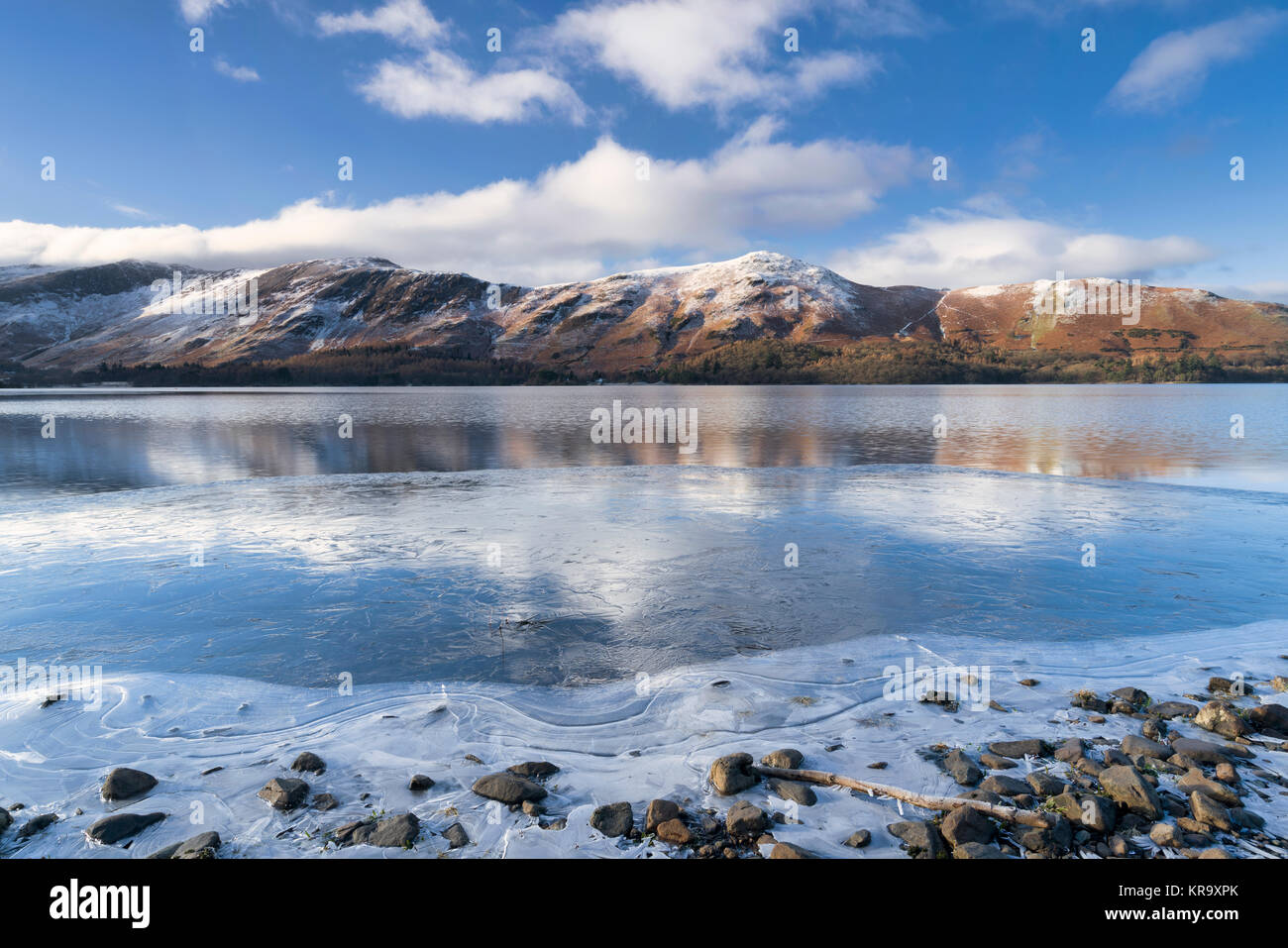 Catbells riflessa nel lago Derwent Water che è parzialmente ricoperto di ghiaccio. Foto Stock