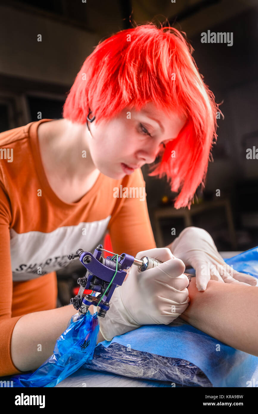 Master tattooist lavorando su professional tattoo machine device in tattoo studio. Foto Stock