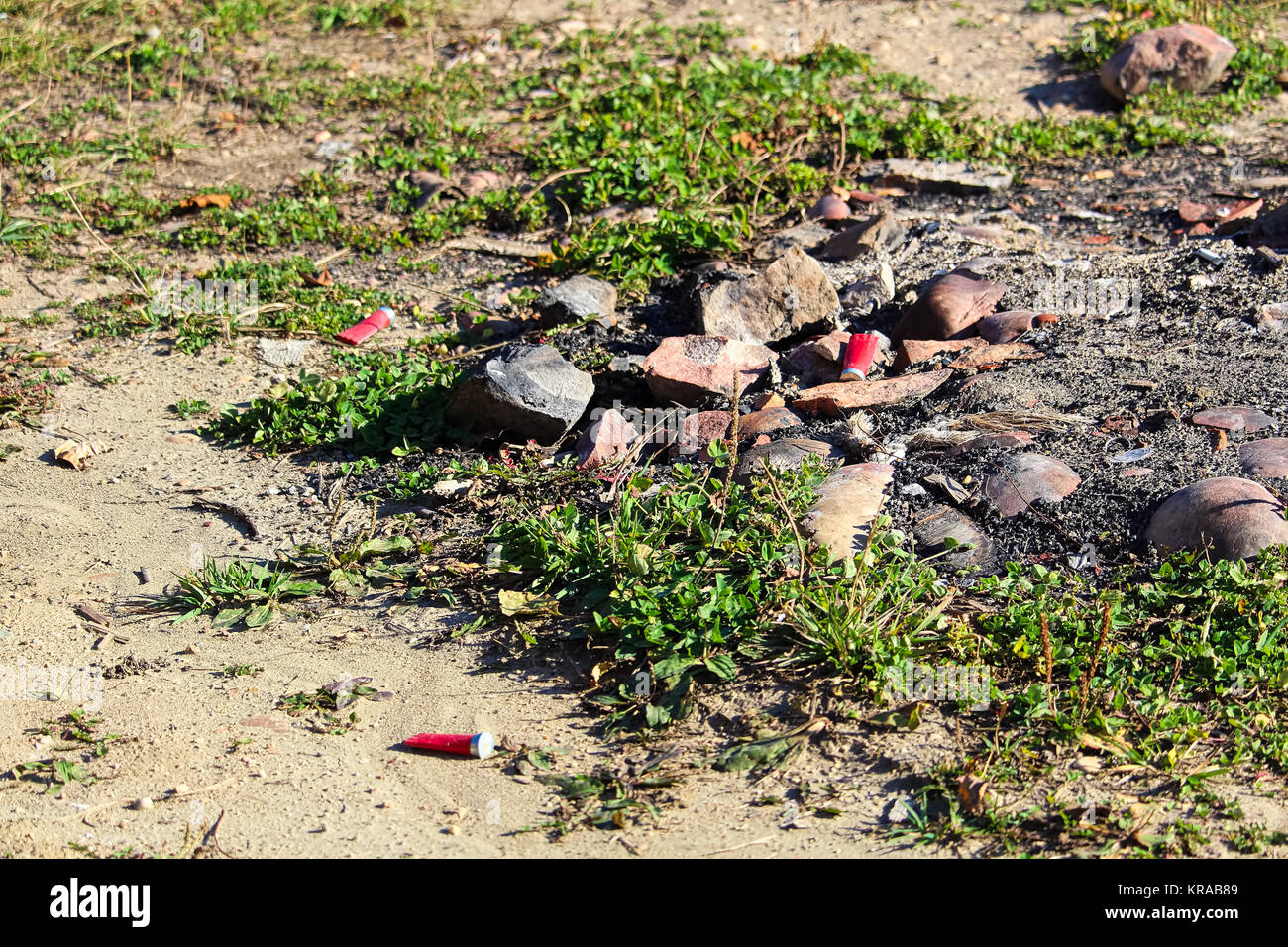 Fucile sparato gusci intorno a un falò di caccia pit. Foto Stock