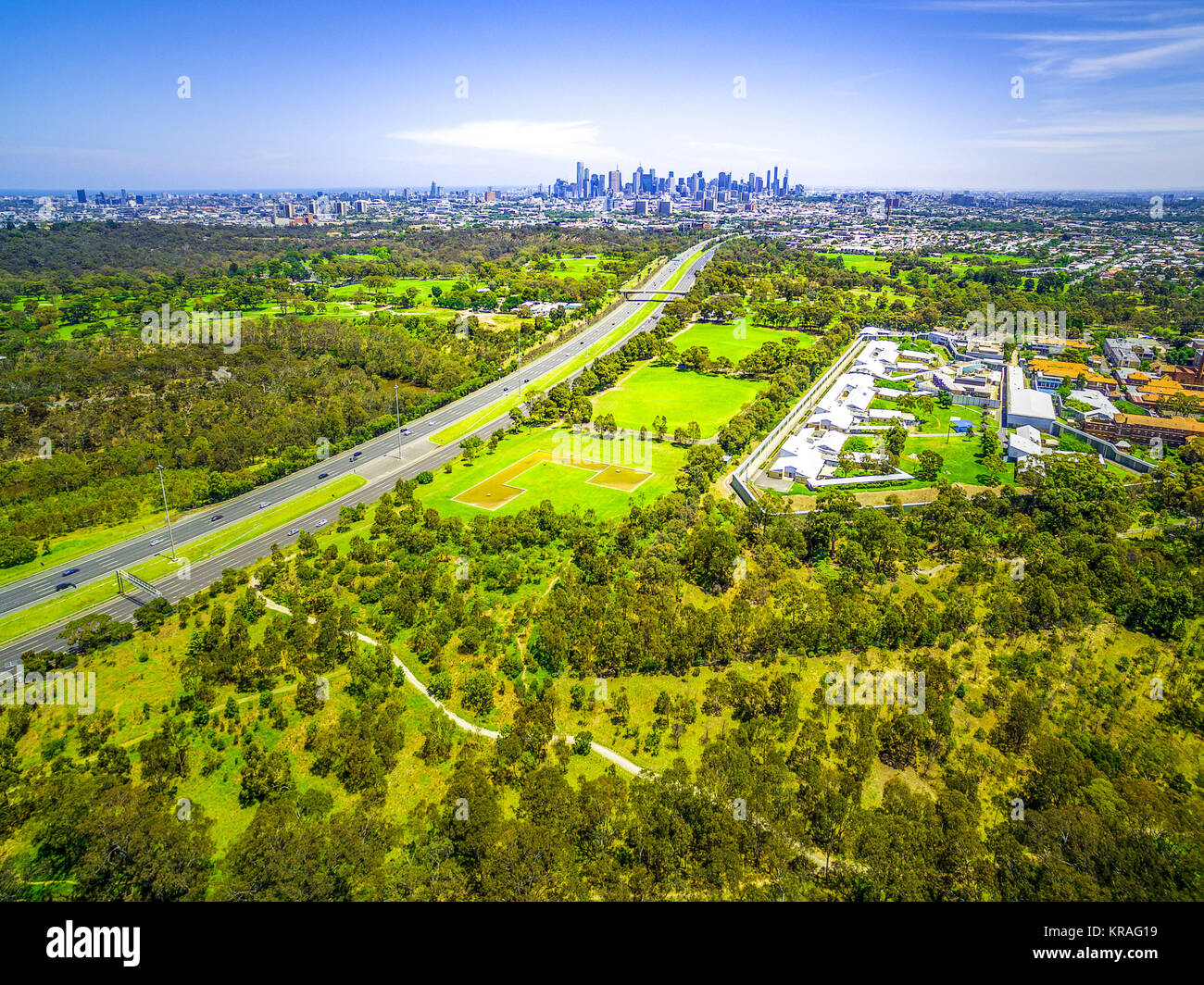 Vista aerea del parco verde, Politecnico di Melbourne e il CBD di Melbourne e grattacieli in lontananza sul giorno di estate Foto Stock