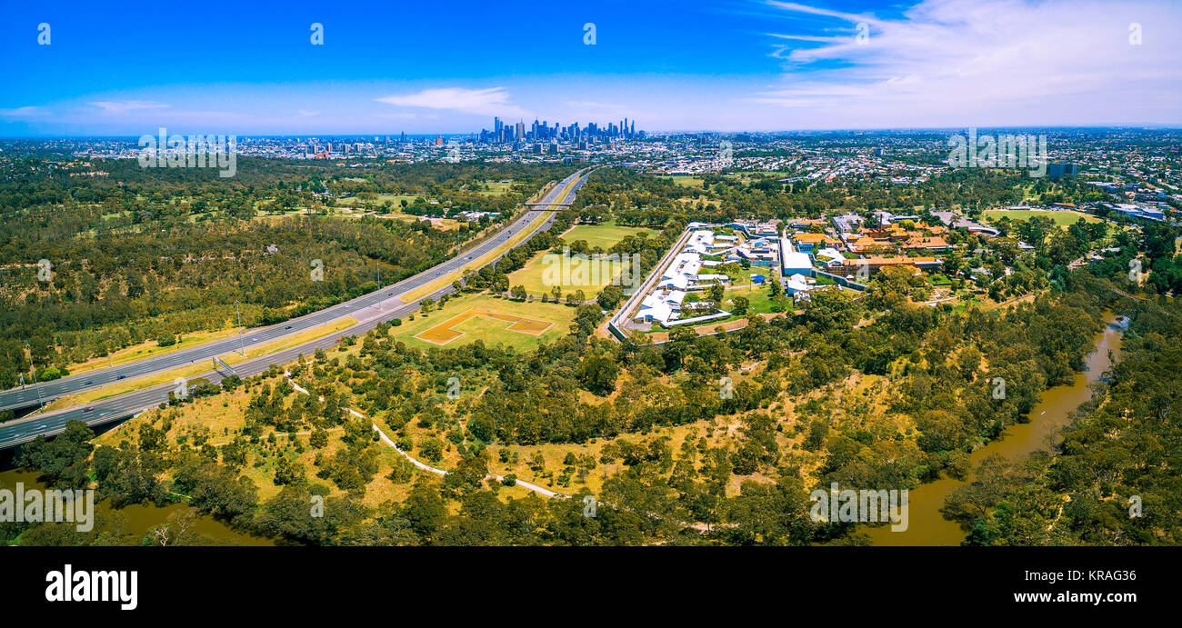 Panoramica aerea di autostrada orientale e il CBD di Melbourne e grattacieli sulla luminosa giornata estiva Foto Stock