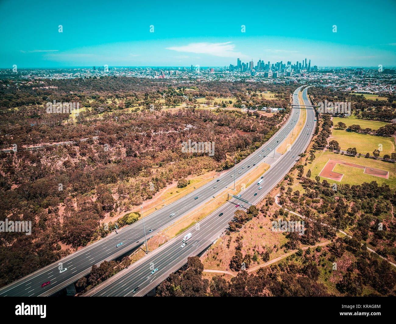 Panoramica aerea di autostrada che porta al centro di Melbourne grattacieli in caldo giorno d'estate Foto Stock