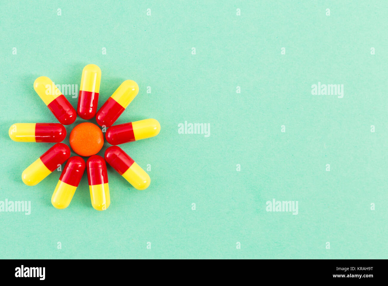Forma di fiore fatta di antibiotici sul verde sfondo medicale o tabella Foto Stock
