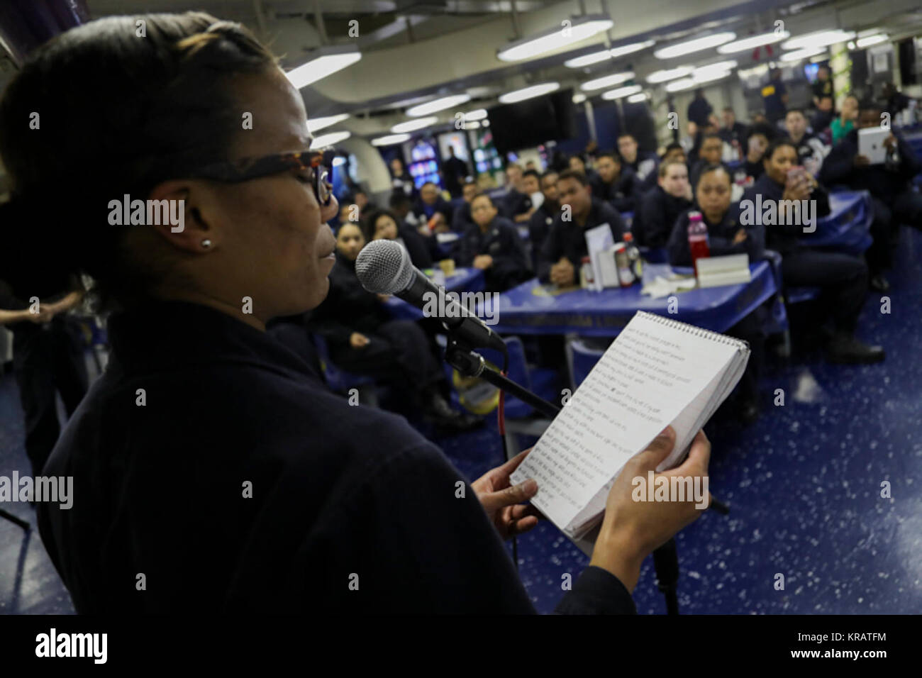 OCEAN (dec. n. 12, 2017) specialista della logistica di terza classe Desiree Alston legge una poesia durante un poetry slam detenute nel disordine dei ponti a bordo della Nimitz-class portaerei USS Abraham Lincoln (CVN 72). Abraham Lincoln è morale, benessere e ricreazione (MWR) ospita eventi come questo in modo che i marinai possono esprimersi in mare. (U.S. Navy Foto Stock