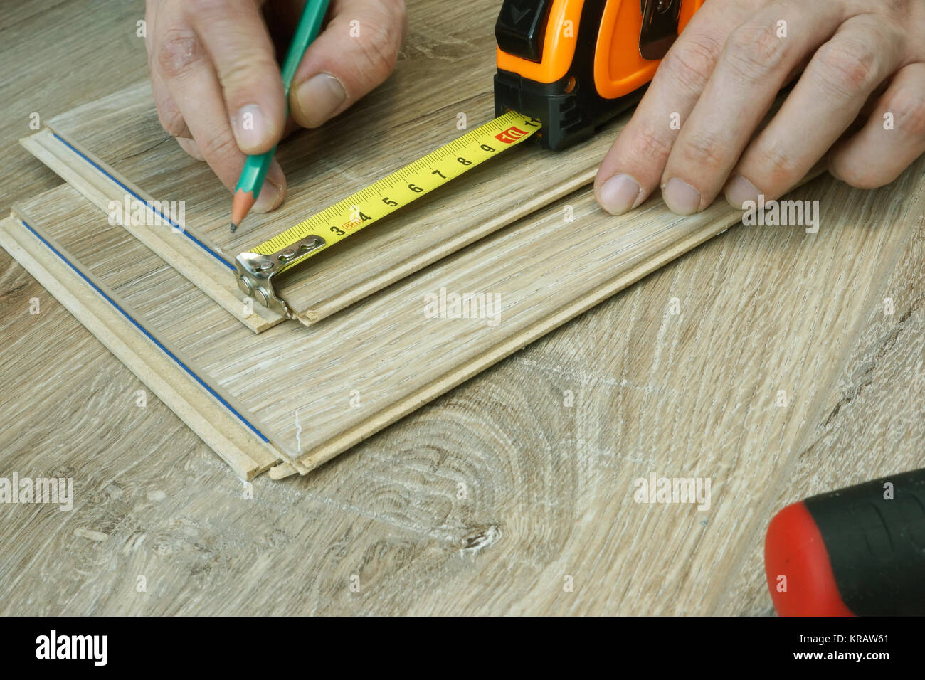 L uomo è la preparazione per l'installazione di pavimenti in laminato. La ristrutturazione del pavimento. Foto Stock