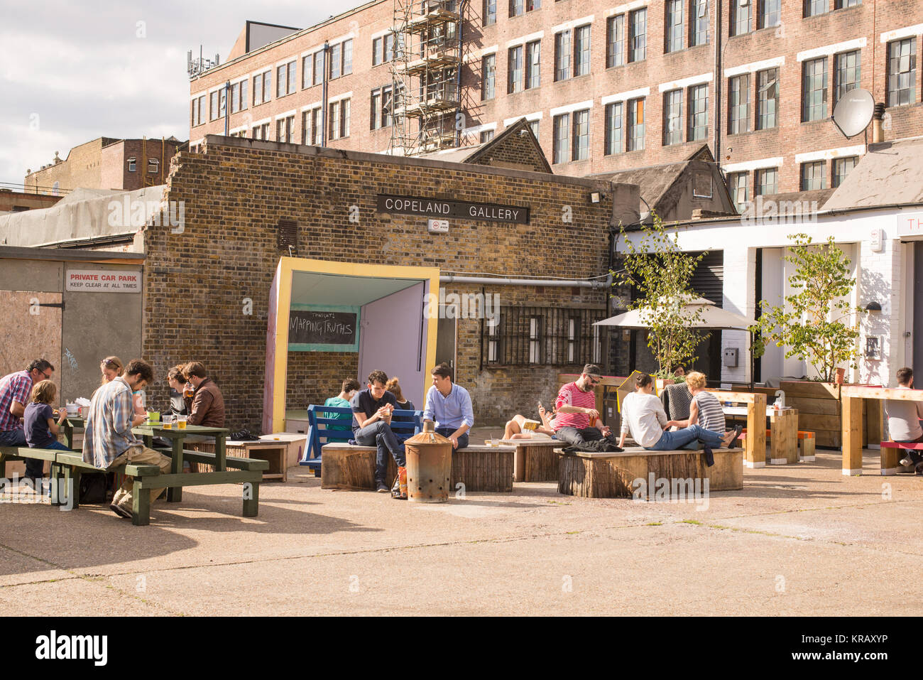 Outdoor bancarelle hipster cafe con persone di godere l'estate presso l'alternativa indie famoso locale il Copeland Gallery Bussey edificio in Peckham, Foto Stock