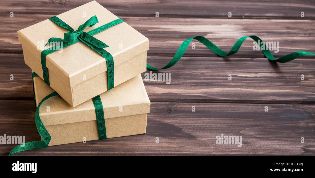 Festive eleganti confezioni regalo decorato con nastro verde su sfondo di legno Foto Stock
