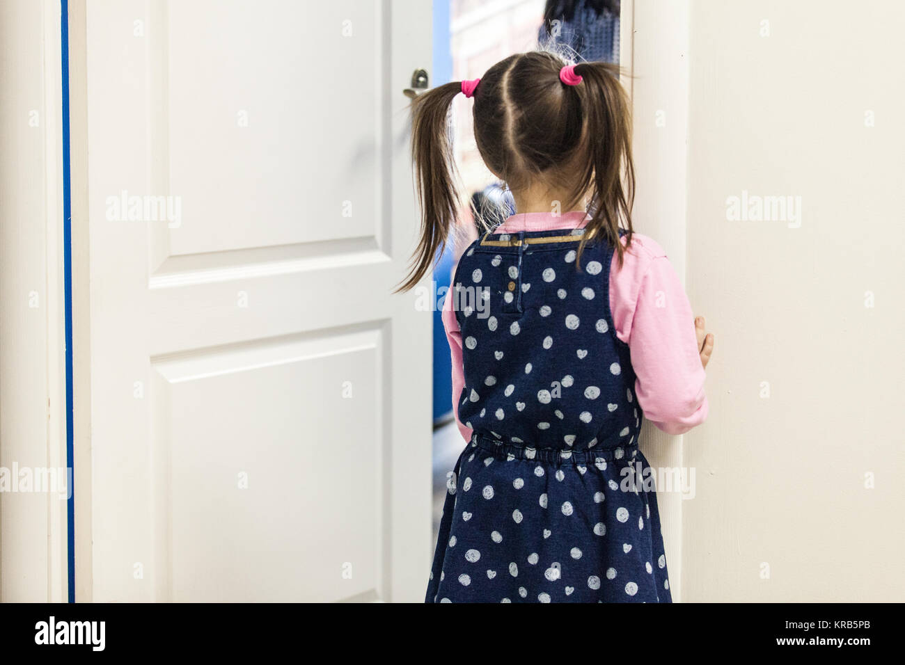 La ragazza (5-7) cercando in aula attraverso la porta vista posteriore Foto Stock