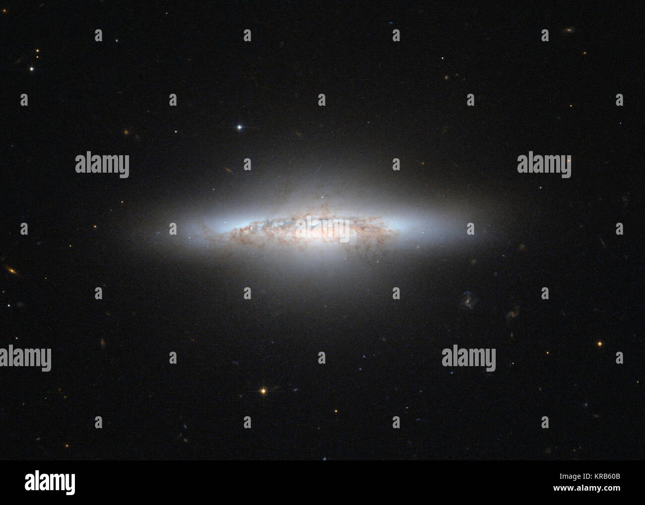 La NASA/ESA Telescopio Spaziale Hubble ha catturato una bella Galaxy che, con il suo colore rossastro e giallo area centrale, appare piuttosto come un esplosione da un film di Hollywood. La galassia, chiamato NGC 5010, è in un periodo di transizione. L'invecchiamento della galassia si muove su dalla vita come una galassia a spirale come la nostra Via Lattea, a un vecchio, meno definito tipo chiamato una galassia ellittica. In questa fase tra gli astronomi si riferiscono a NGC 5010 come una galassia lenticolare, che ha caratteristiche di entrambe le spirali ellittiche e. NGC 5010 si trova a circa 140 milioni di anni luce di distanza nella costellazione della Vergine (Vergine) Foto Stock