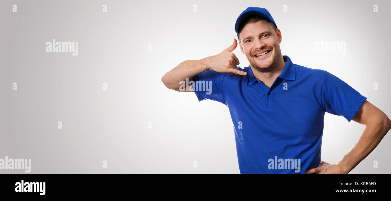 Lavoratore in uniforme blu facendo chiamata gesto Foto Stock