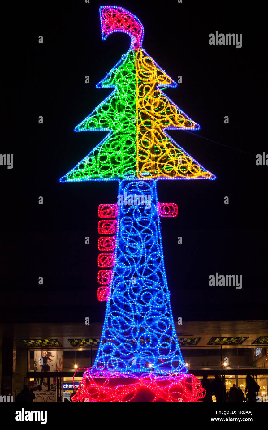 Il luminoso colorato albero di Natale luci da Marco Lodola, Venezia , Italia al di fuori della stazione ferroviaria di Santa Lucia a notte con sagome di turista Foto Stock