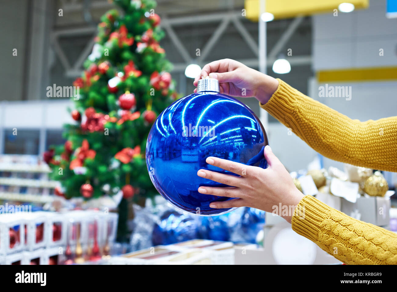 Blu grande albero di Natale palla in mani femminili Foto Stock