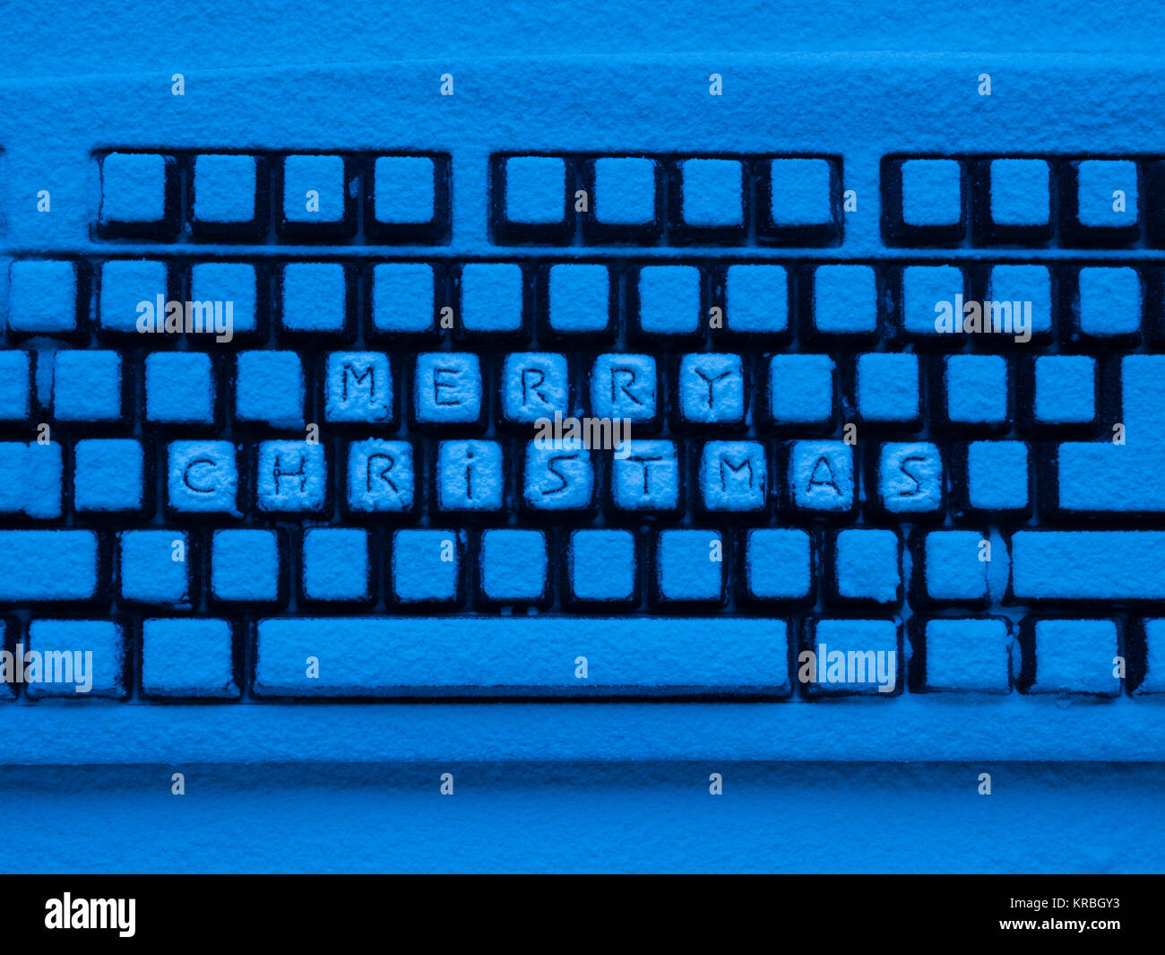 Tastiera per computer con neve illuminata dal blu luce al neon con  iscrizione buon natale Foto stock - Alamy