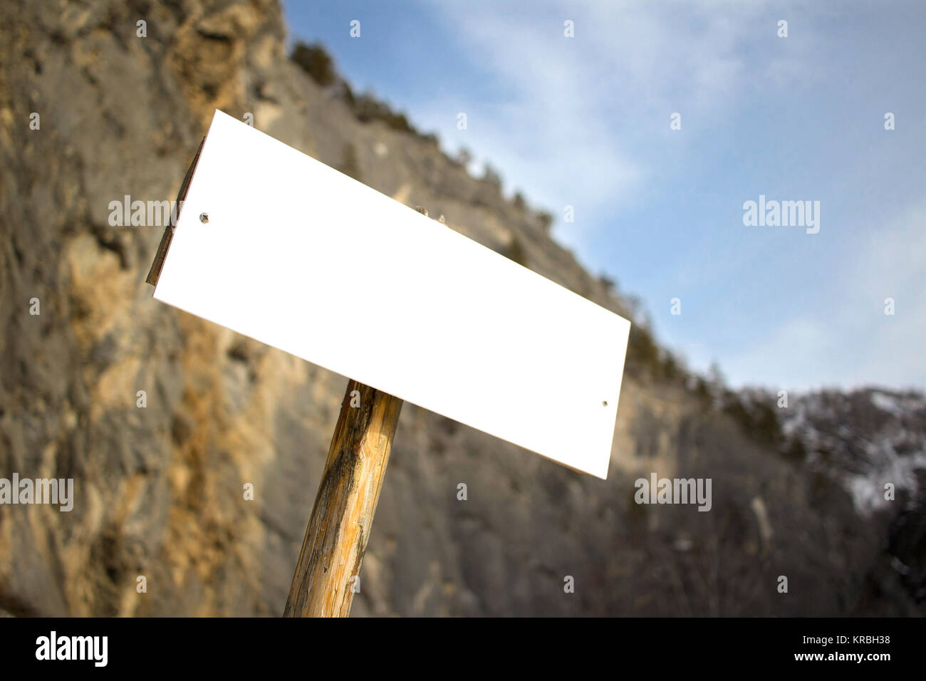 Avventura blank board cartello bianco sul bokeh vista montagne, sulla giornata di sole arrampicate su roccia alpinismo turisti Foto Stock
