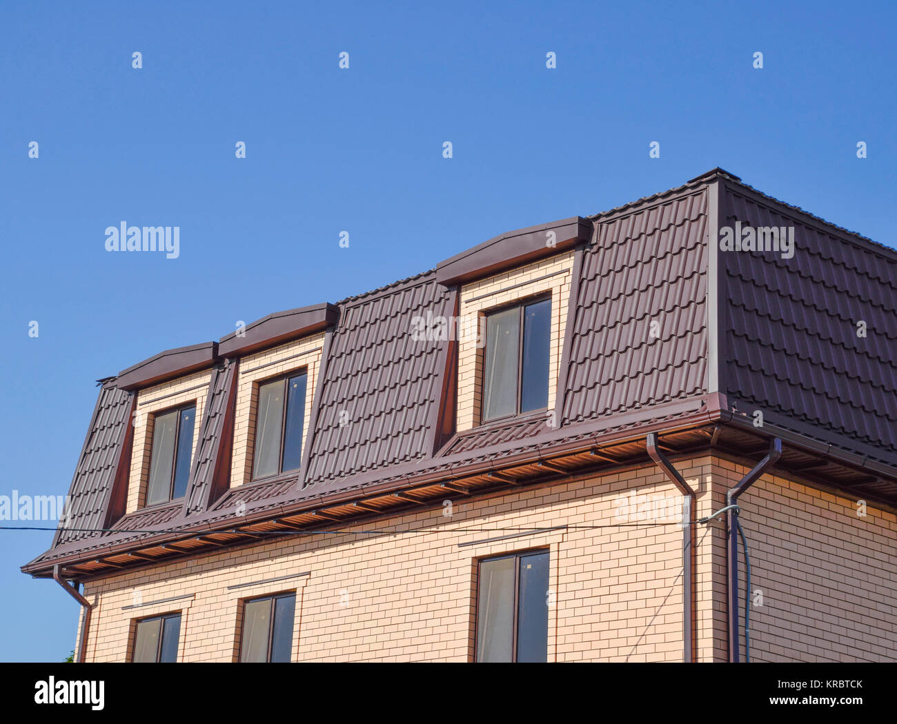 La casa con le finestre in plastica e un tetto del foglio ondulato Foto Stock