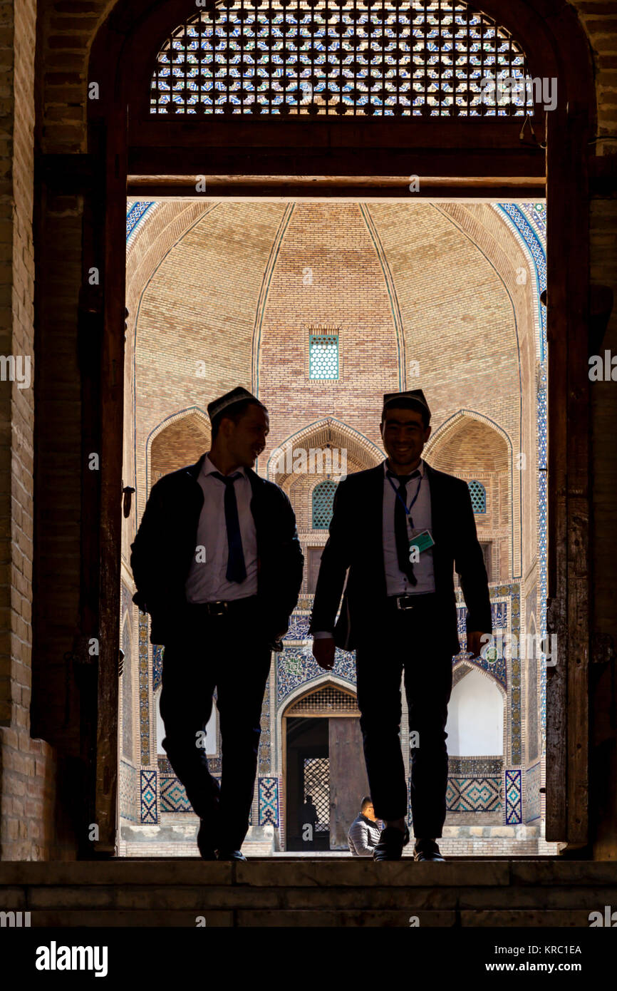 Due gli uomini uzbeki immettendo la moschea Kalyan, Bukhara, Uzbekistan Foto Stock