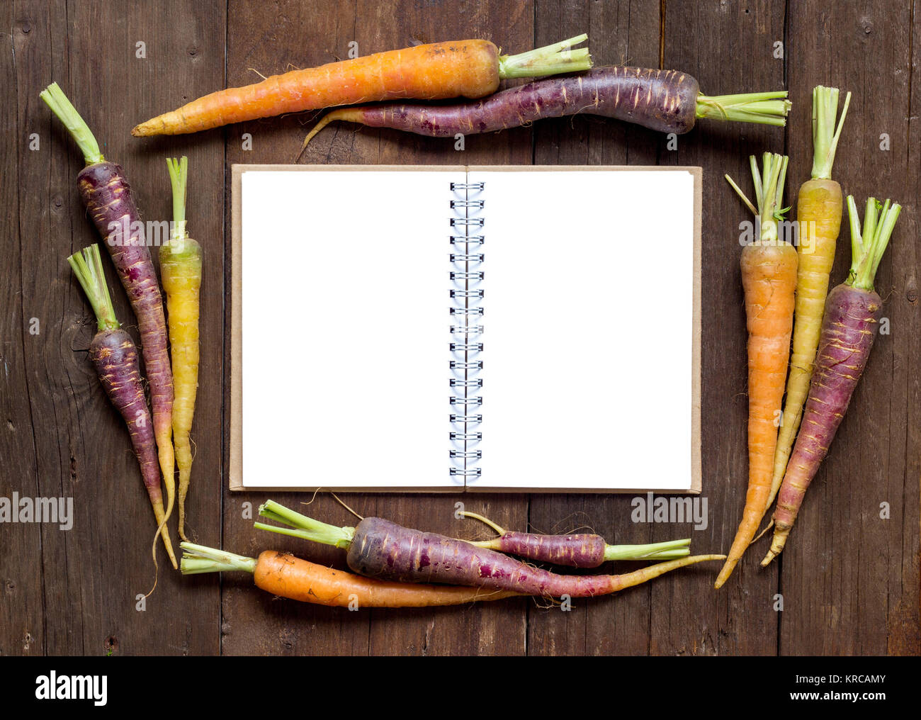 Fresche biologiche rainbow carote con libro delle ricette Foto Stock