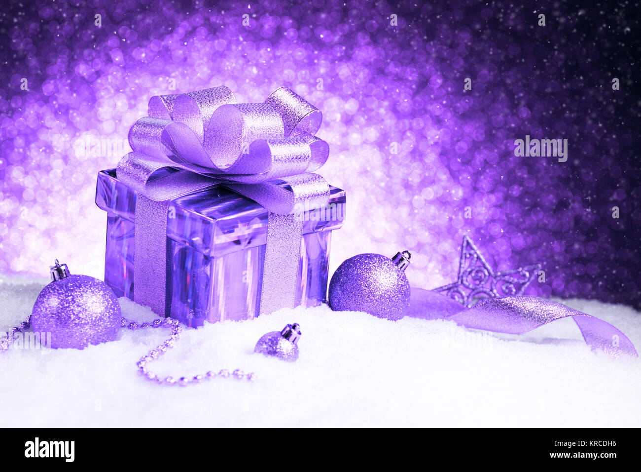 Natale viola confezione regalo con sfere e stella sulla neve Foto Stock