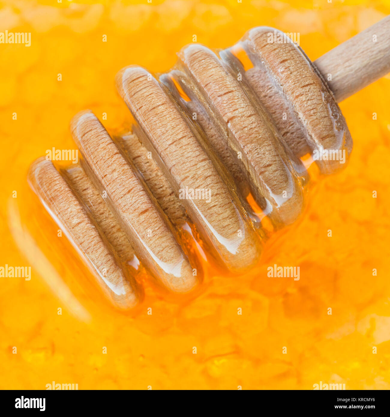 Il miele in legno bilanciere su honeycomb close up Foto Stock